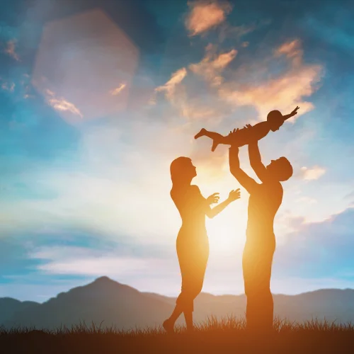 Genitori che giocano con il figlio al tramonto